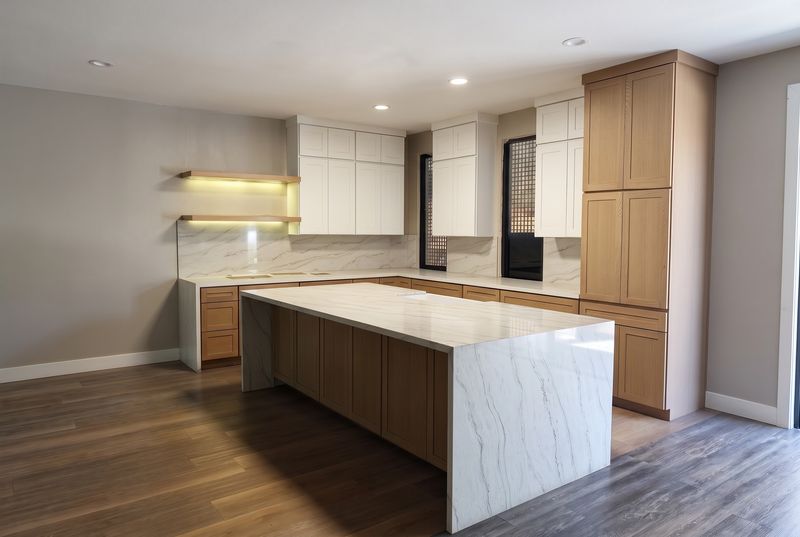 A white and oak kitchen with a waterfall island