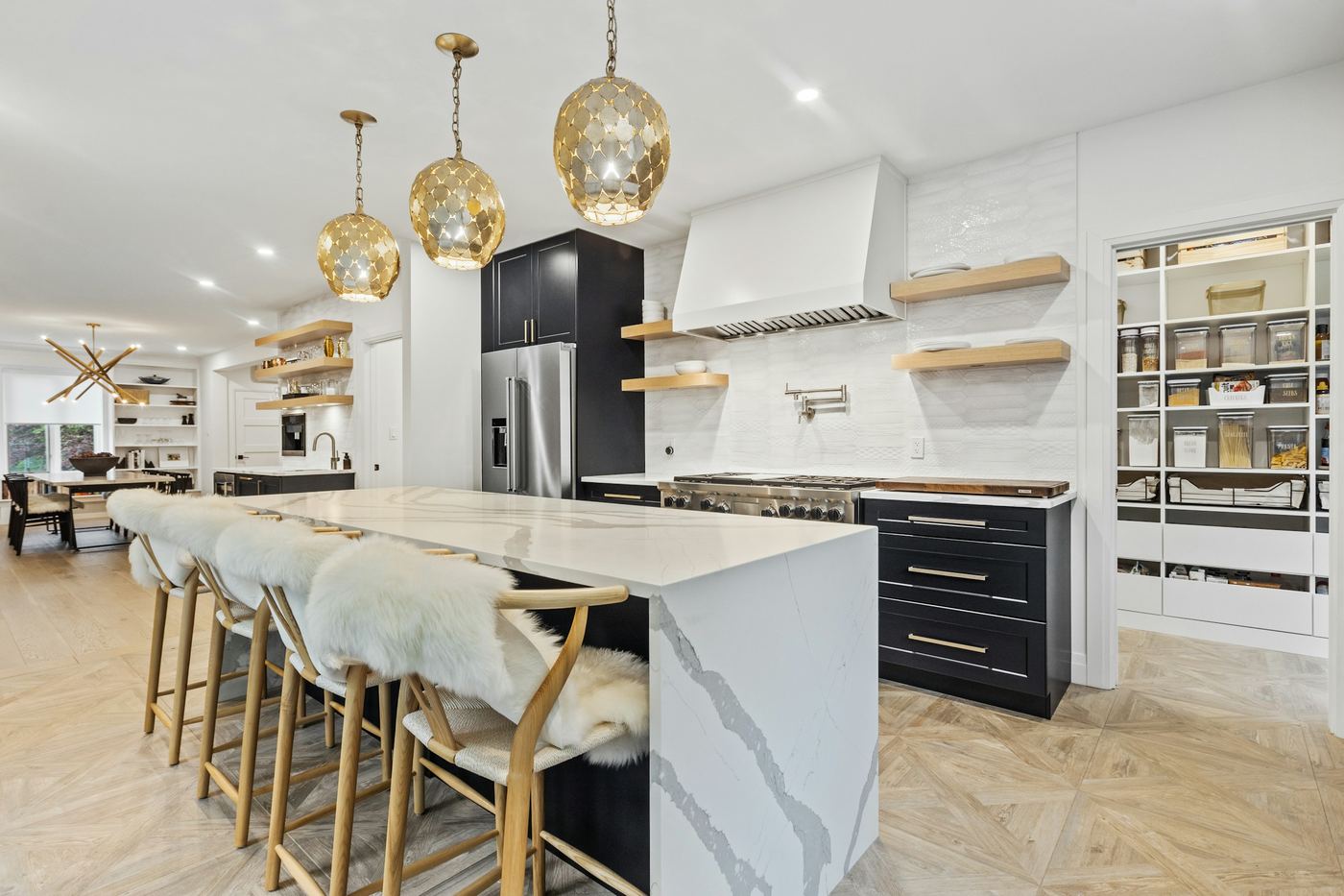 A bright white kitchen with an island and stools