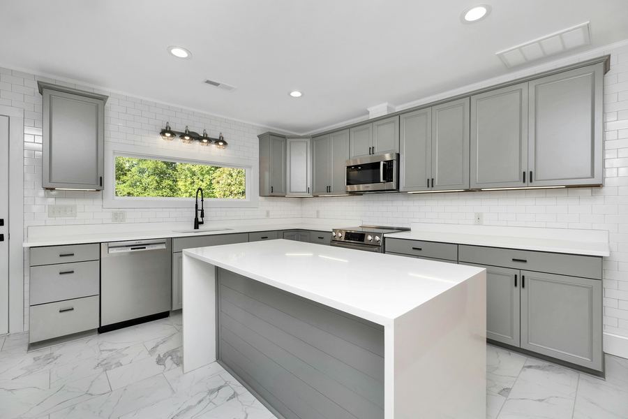 A gray Shaker kitchen with a white island
