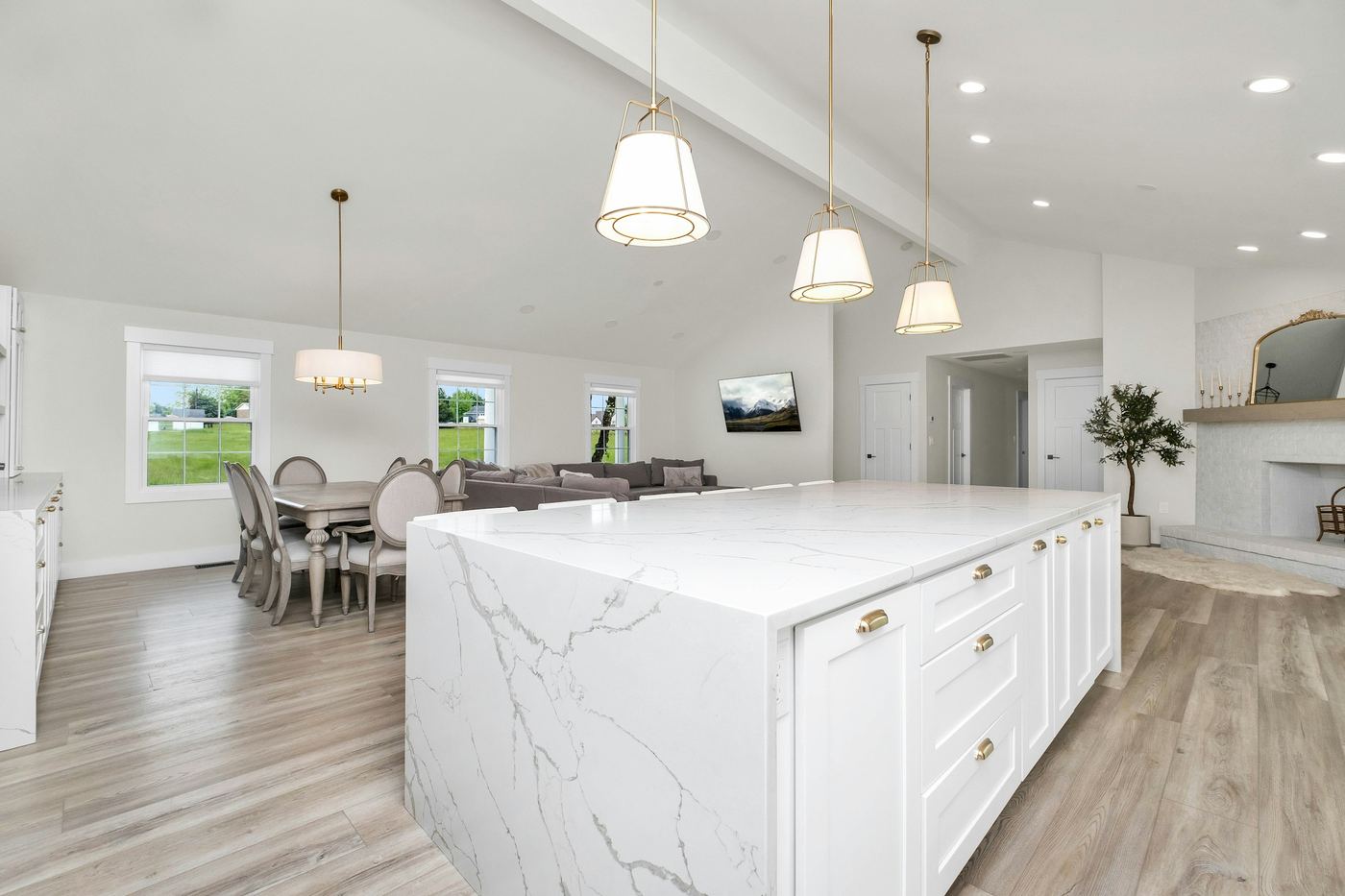 A bright white kitchen with an island and stools