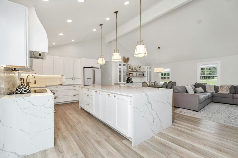 A bright kitchen with a long marble island