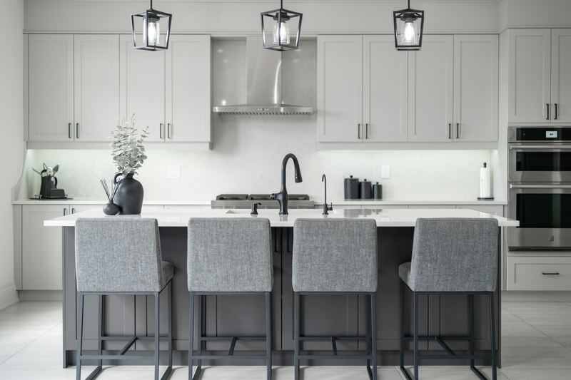 A white kitchen with gray bar stools